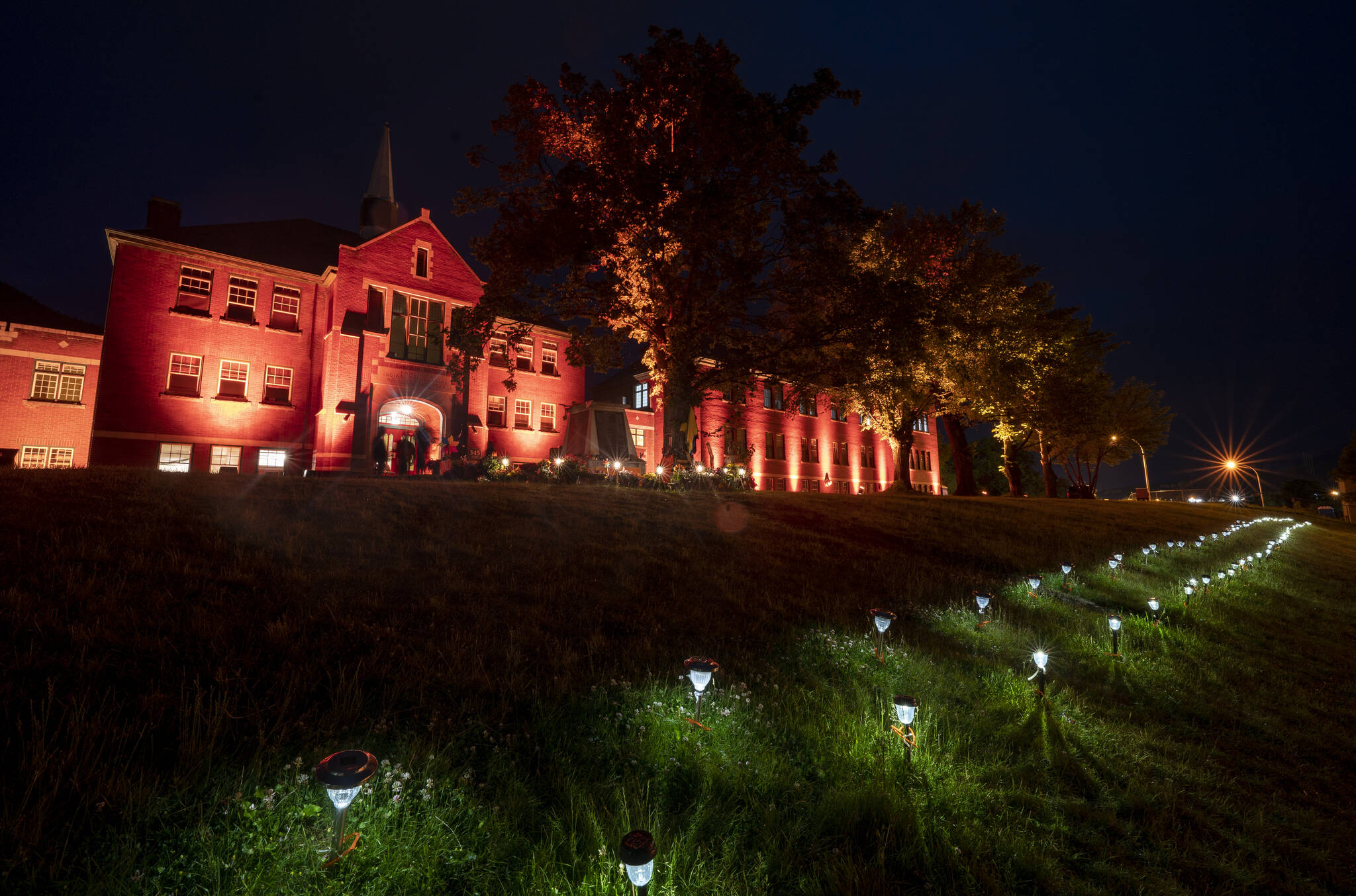 Two hundred and fifteen lights are placed on the lawn outside the Residential School in Kamloops, B.C., Saturday, June, 13, 2021. The remains of 215 children were discovered buried near the former Kamloops Indian Residential School earlier this month. THE CANADIAN PRESS/Jonathan Hayward