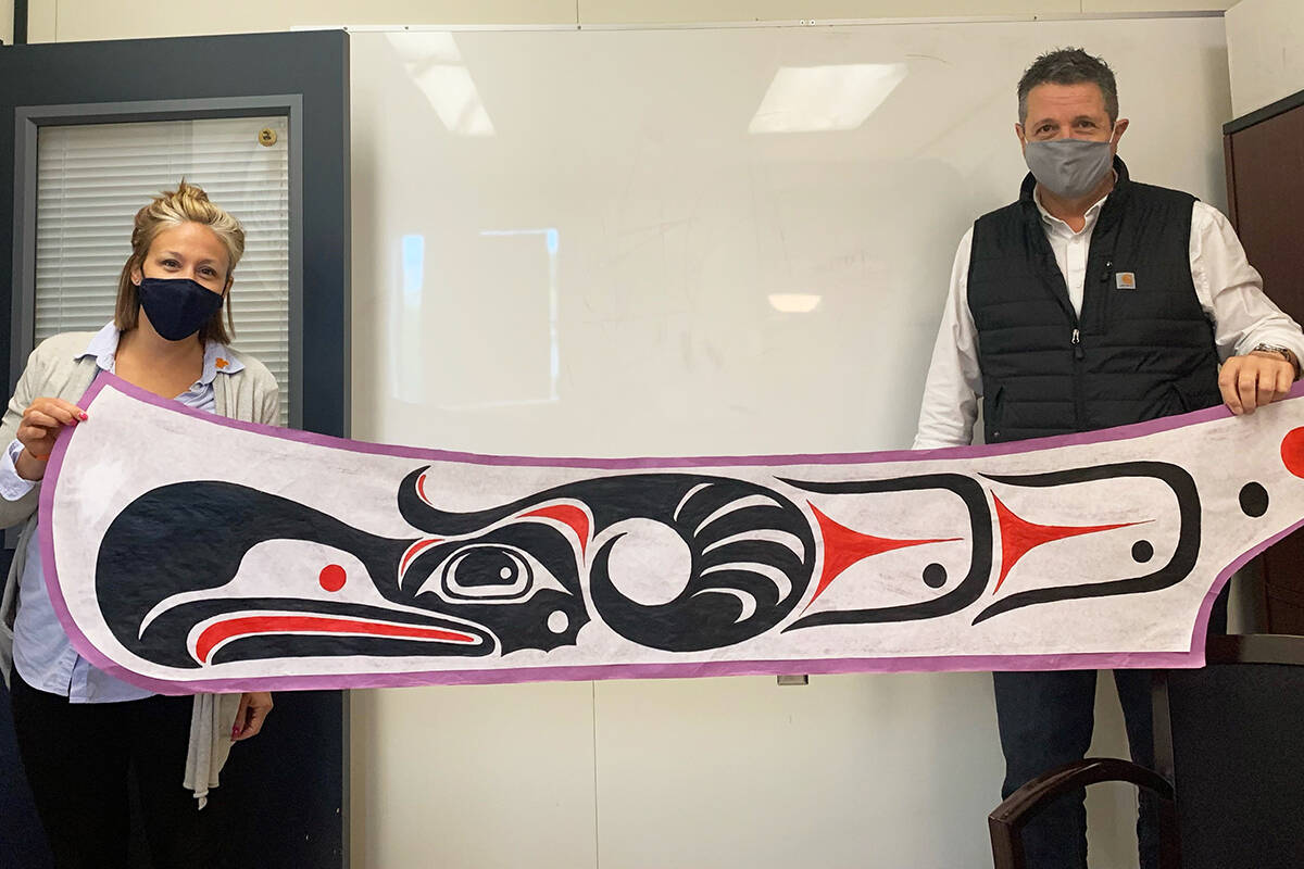 Teachers Gillian Le Rose and Rick Fabris hold a canoe that’s part of a unique reconciliation project at Westshore Colwood School. (Photo courtesy of Sooke School District)