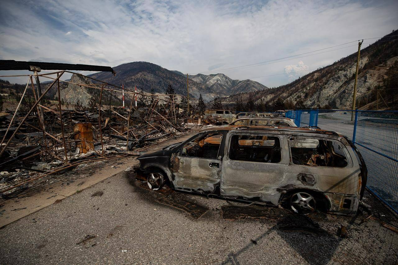 The remains of a large structure and vehicles destroyed by the Lytton Creek wildfire are seen on the side of the Trans-Canada Highway near Lytton on Aug. 15, 2021. (THE CANADIAN PRESS/Darryl Dyck)