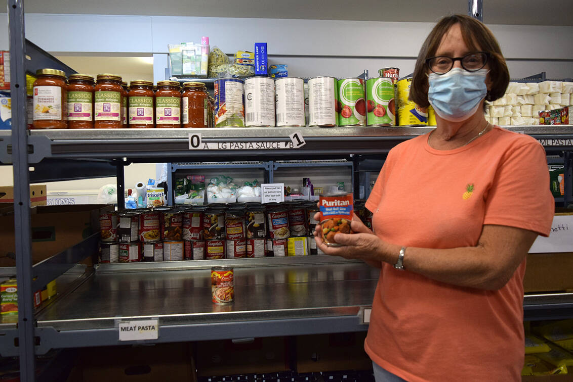 Goldstream Food Bank president and volunteer Gayle Ireland stands beside the meat pasta shelf with one of the sole cans left over following the Sept. 14 distribution. (Kiernan Green/News Staff)