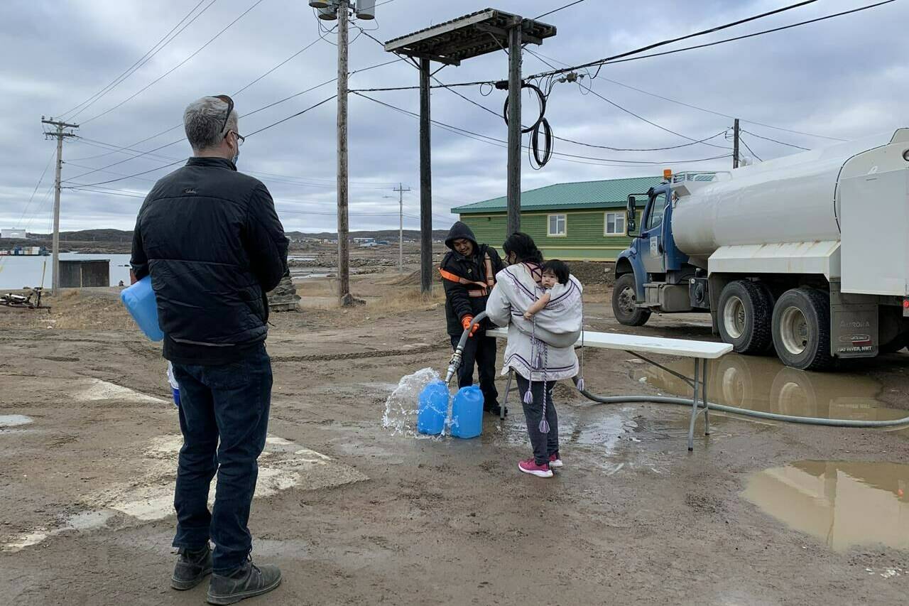 Residents line up to fill containers with potable water in Iqaluit, Nunavut on Thursday, Oct. 14, 2021. The Nunavut government has declared a 14-day state of emergency in Iqaluit after water in the capital was deemed undrinkable and potentially tainted with petroleum. The first shipment of potable water for residents also arrived by plane, with more expected to be delivered in the coming days. THE CANADIAN PRESS/Emma Tranter