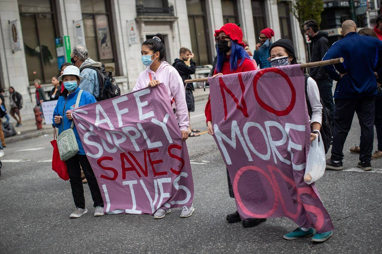 People hold a banner during a Vancouver march on International Overdose Awareness Day in August. B.C. is urging the federal government to decriminalize possession of personal amounts of illicit drugs as a way to help save lives. (THE CANADIAN PRESS/Darryl Dyck)