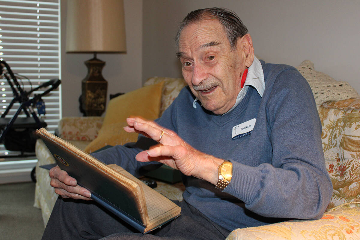 Second World War veteran and former RCAF pilot Donovan Nixon points to a logbook containing every flight he ever did. (Jake Romphf/News Staff)