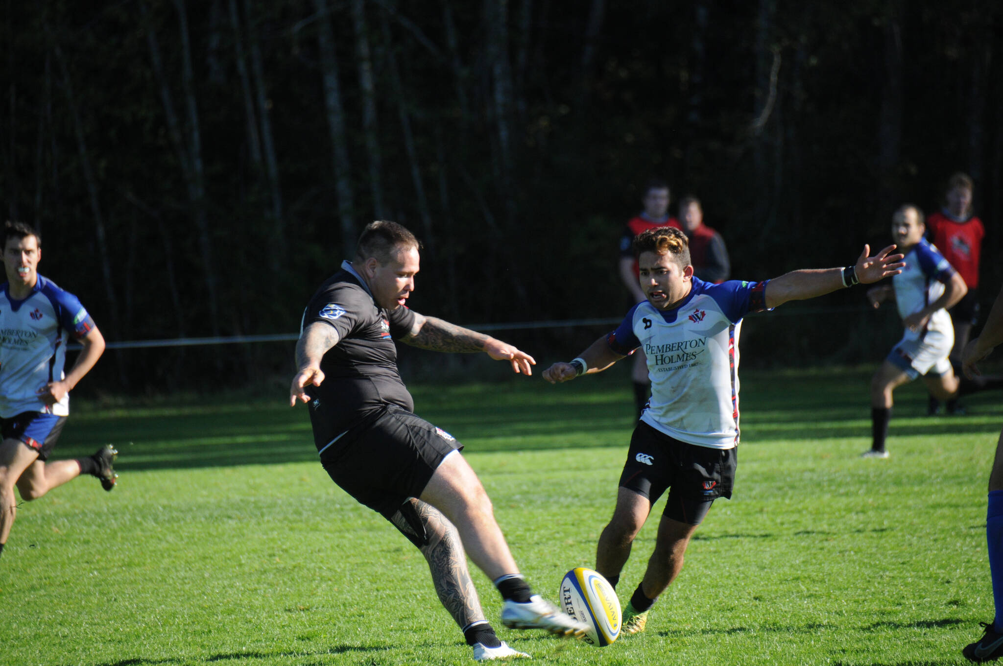 A Port Alberni Black Sheep player, left, attempts a kick while a Westshore player comes in for the block during a B.C. Rugby Union game at the Black Sheep pitch on Argyle Street, Saturday, Oct. 30, 2021. (SUSAN QUINN/ Alberni Valley News)