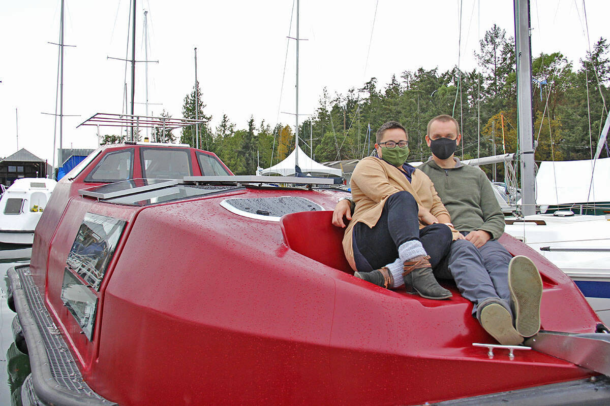 Dani Tate-Stratton (left) and Toryn Sundstrom (right) sit atop their recently acquired BC Ferries lifeboat, a project piece they plan to turn into their home. (Jane Skrypnek/News Staff)