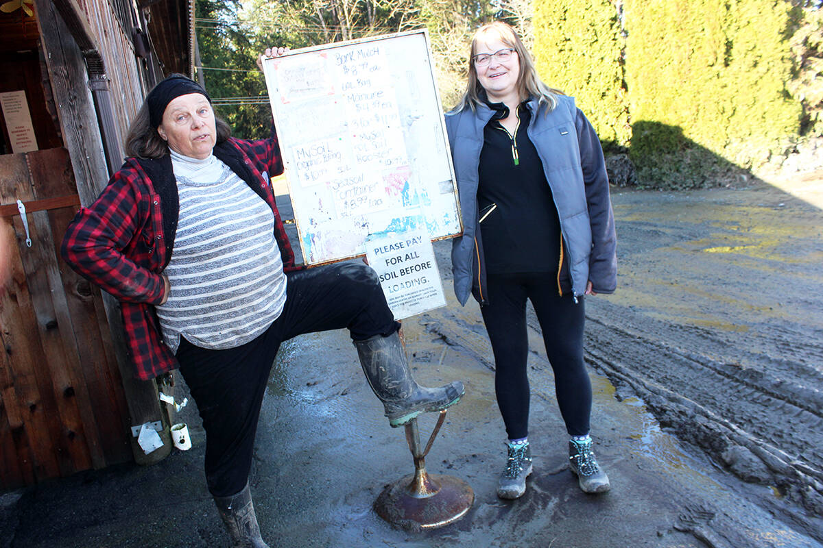 Amid the muck, France Bournazel, left, and Tammy Calverley try to lighten the mood during intense ongoing clean-up from flood waters at the Russell Farm Market. (Photo by Don Bodger)