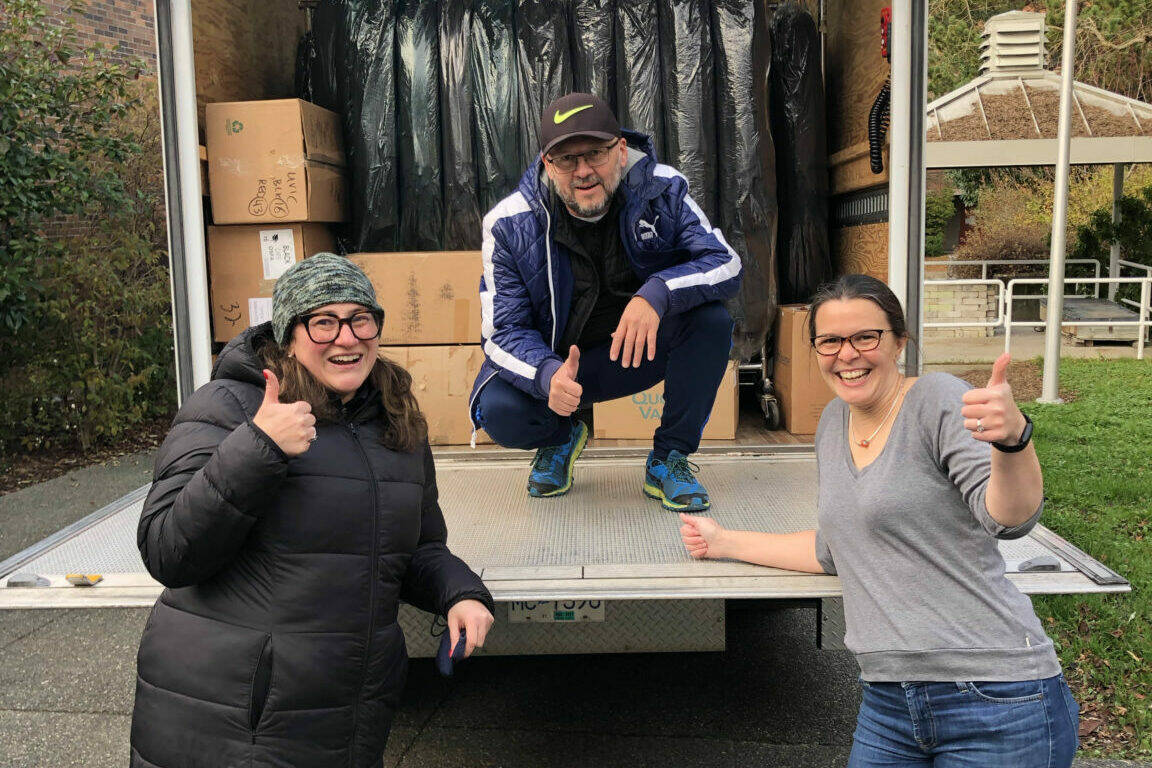 Liz King (left) and Rodolfo Calero from UBC join UVic’s Jeanie Gunn in loading 600 caps and gowns onto a truck bound for UBC. (Courtesy of UBC)