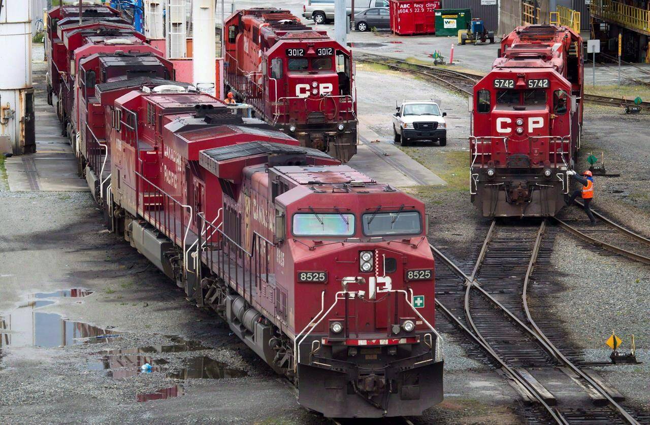 A Canadian Pacific Rail maintenance worker climbs onto a locomotive at the company’s Port Coquitlam yard east of Vancouver, B.C., on Wednesday May 23, 2012. Canada’s two largest railways are facing service disruptions following mudslides that have wiped out tracks in British Columbia and caused at least one partial derailment. (THE CANADIAN PRESS/Darryl Dyck)