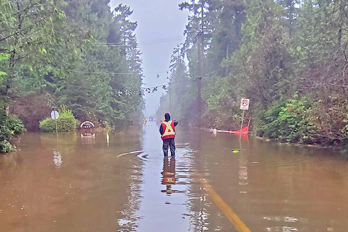 Local excavator Will Smith snapped this photo of a District of Tofino worker navigating a flooded Hellesen Drive last week. On Thursday, Nov. 25 Tofino issued a rainfall and flood advisory and activated its Emergency Operations Centre while Ucluelet closed access to the Wild Pacific Trail due to wave hazards. (Will Smith photo)