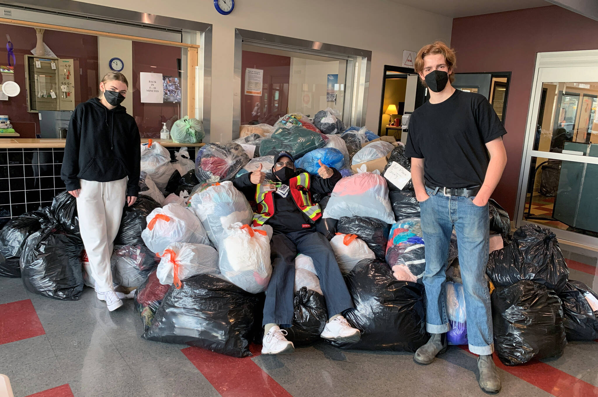 Students from Camosun College’s criminal justice program, pictured alongside an Our Place volunteer (centre), gathered donated clothes for the organization. (Our Place Society/Twitter)