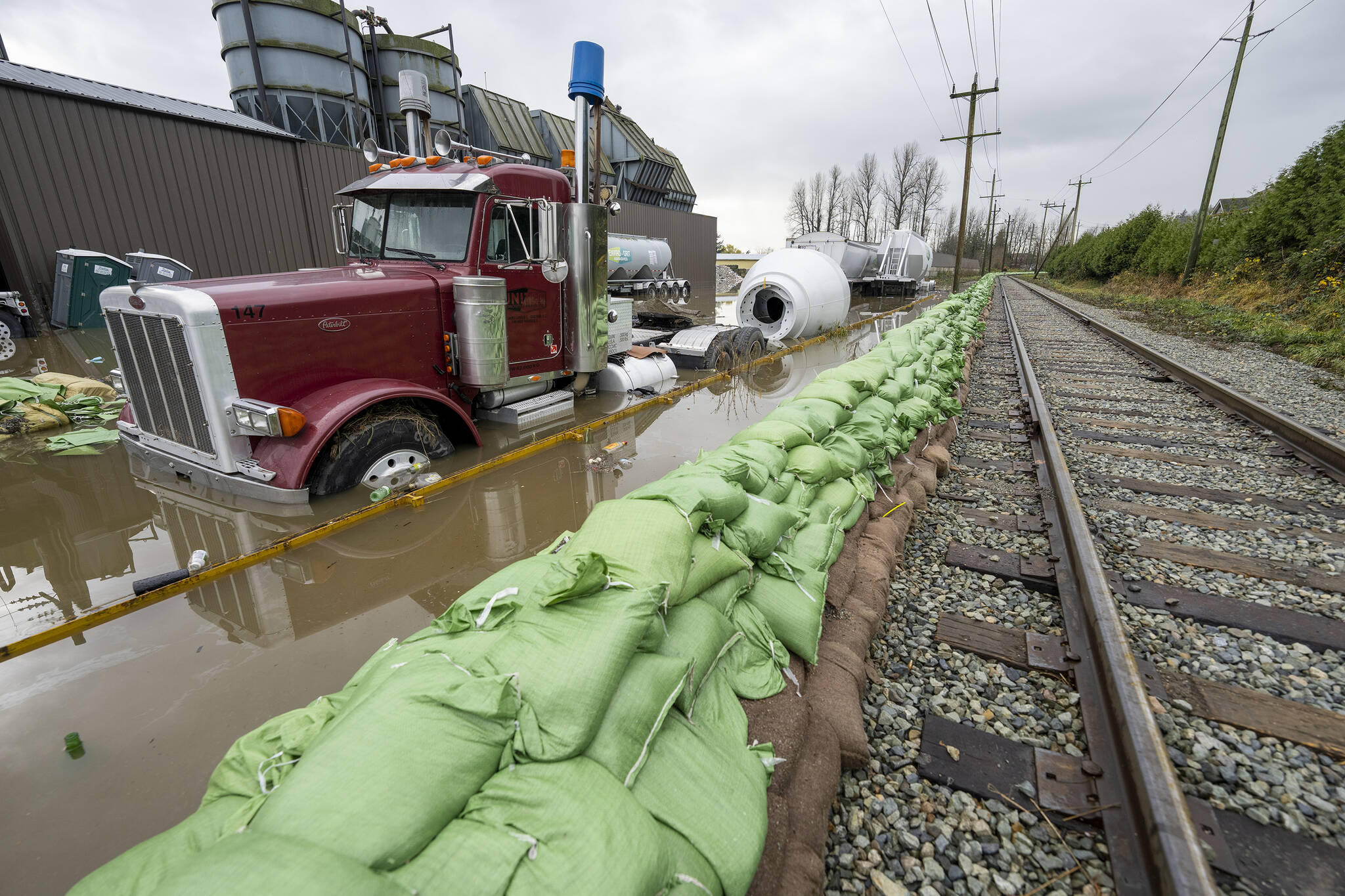 A truck gets swallowed up by rising flood waters from the United States as waters cross the border into Abbotsford, B.C., Monday, November 29, 2021. THE CANADIAN PRESS/Jonathan Hayward