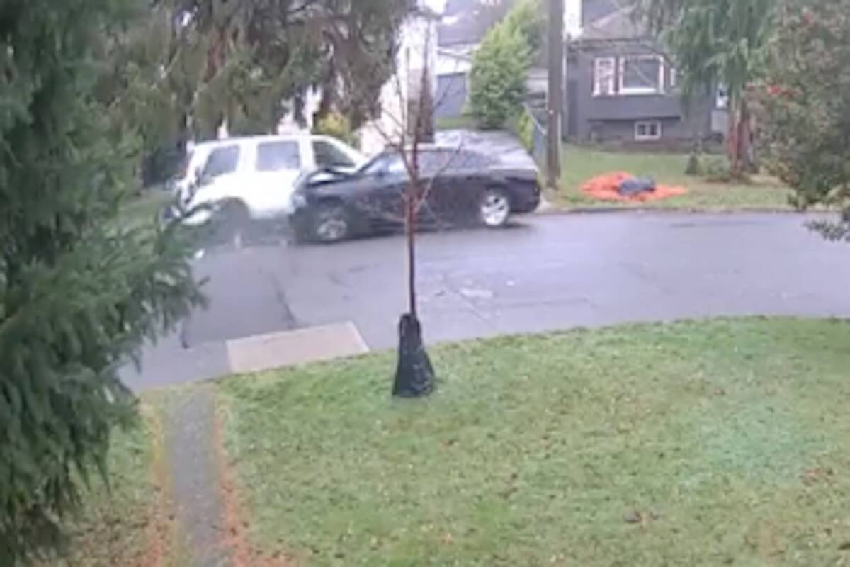 A white van drives around a black unoccupied vehicle on Hampton Road after pushing it backward on Dec. 7. (Photo courtesy of Saanich police)