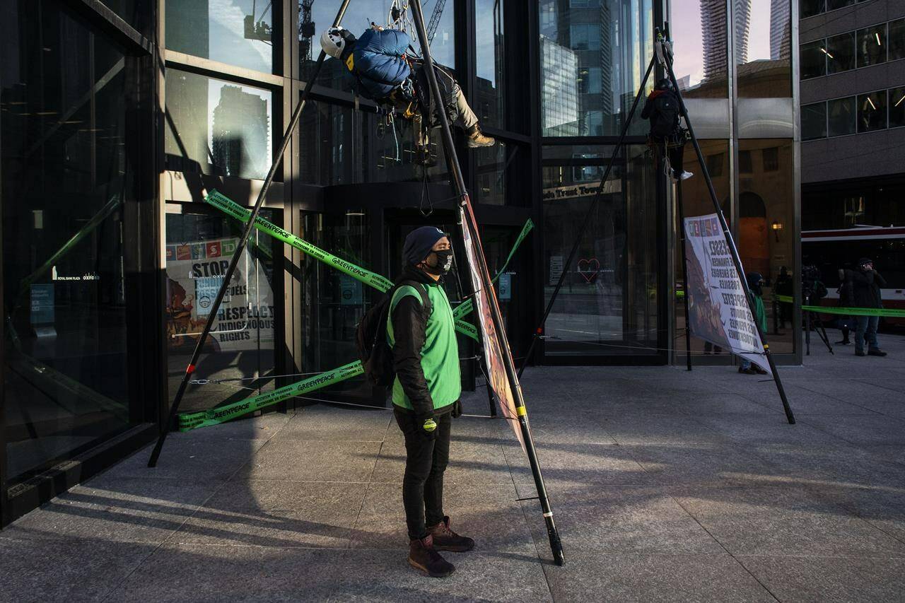 Greenpeace activists stage a demonstration outside a bank in Toronto, as they protest major Canadian bank’s investment in fossil fuels, on Tuesday, December 7, 2021. THE CANADIAN PRESS/Chris Young