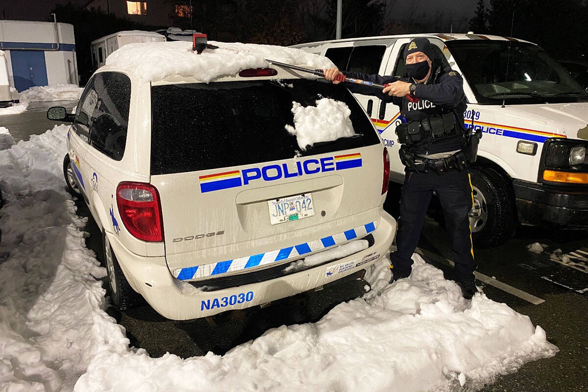 Const. Marty Kortas clears snow off police vehicles at the Nanaimo RCMP detachment. (Photo submitted)