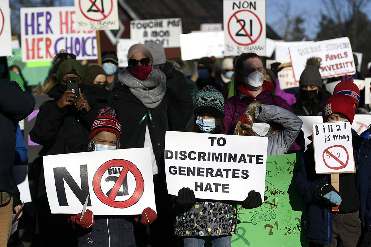 Children stand at the front of a rally against Quebec’s Bill 21, which prohibits some public sector workers from wearing religious symbols at work, after a teacher was removed from her position because she wears a hijab, in Chelsea, Que., on Tuesday, Dec. 14, 2021. THE CANADIAN PRESS/Justin Tang