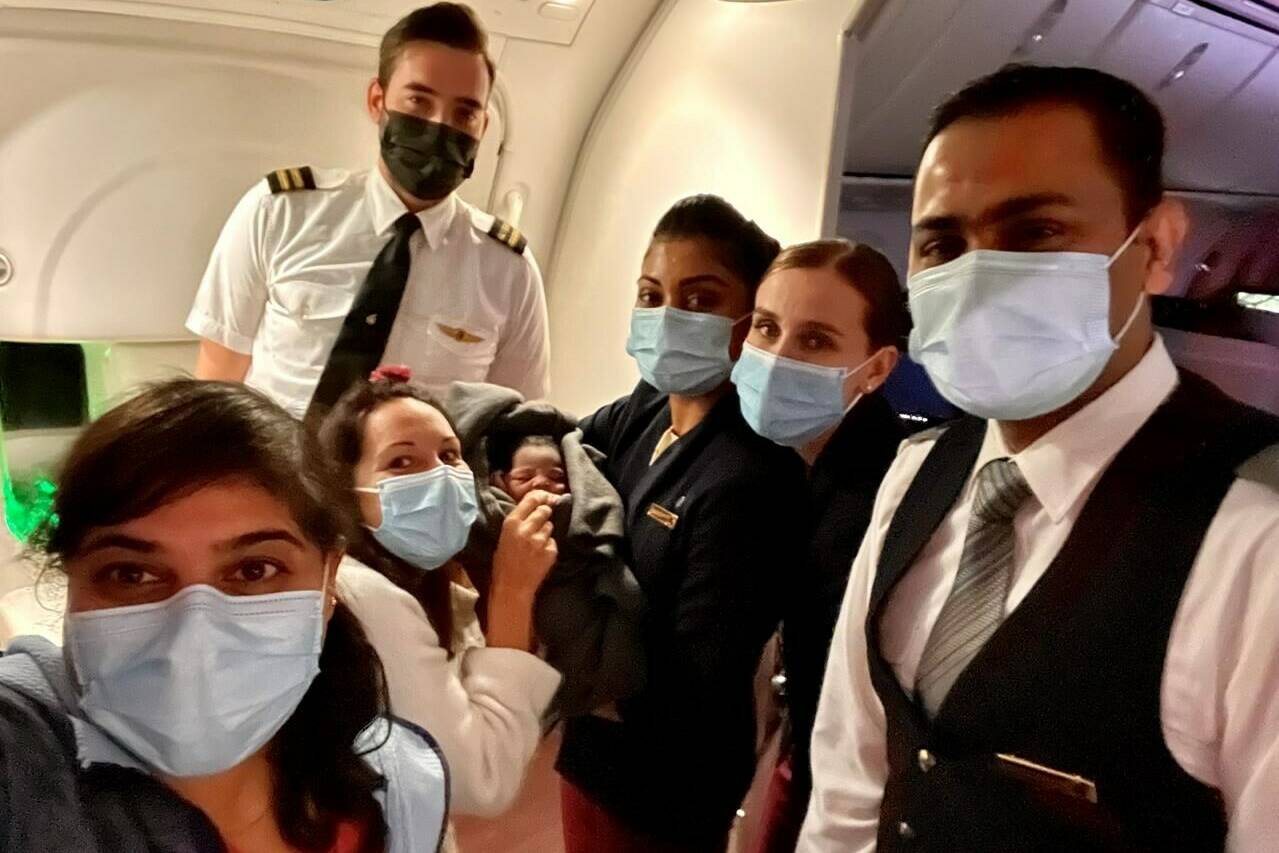 Dr. Aisha Khatib, left, poses for a selfie with crew members, pediatrician Carola Buscemi, second from left, and a baby who the two medical professionals delivered on board the flight. Khatib was on the final leg of her multi-stop voyage from Toronto to Entebbe, Uganda, last month when she heard an announcement asking if there were any medical personnel on the plane, was ushered to the back of the plane, and found a woman in labour with a baby well on its way. THE CANADIAN PRESS/HO-Aisha Khatib, *MANDATORY CREDIT*