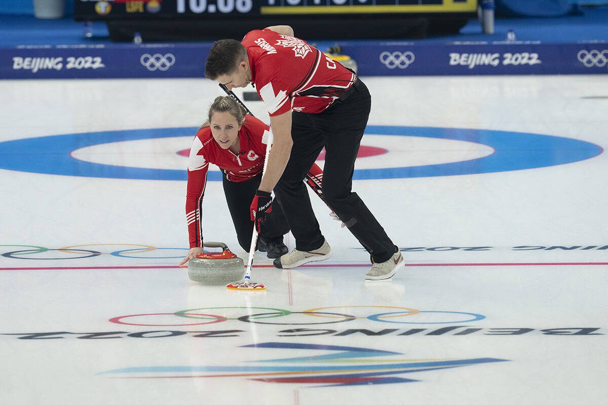 Canada’s Rachel Homan delivers a rock as John Morris sweeps during preliminary round mixed curling against Czech Republic Sunday, February 6, 2022 at the 2022 Winter Olympics in Beijing. THE CANADIAN PRESS/Ryan Remiorz