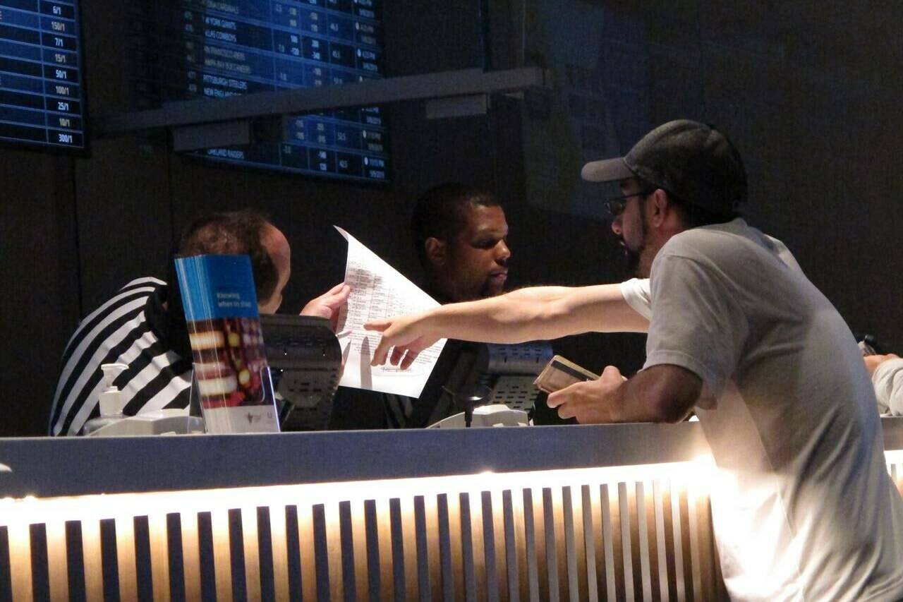 FILE - A gambler makes a sports bet at Bally's casino in Atlantic City N.J., Sept. 5, 2019. A record 31.5 million Americans plan to bet on this year's Super Bowl, according to the gambling industry's national trade group. The American Gaming Association on Tuesday, Feb. 8, 2022, released its annual predictions for wagering on pro football's championship game, forecasting that over $7.6 billion will be bet legally and otherwise. (AP Photo/Wayne Parry, File)