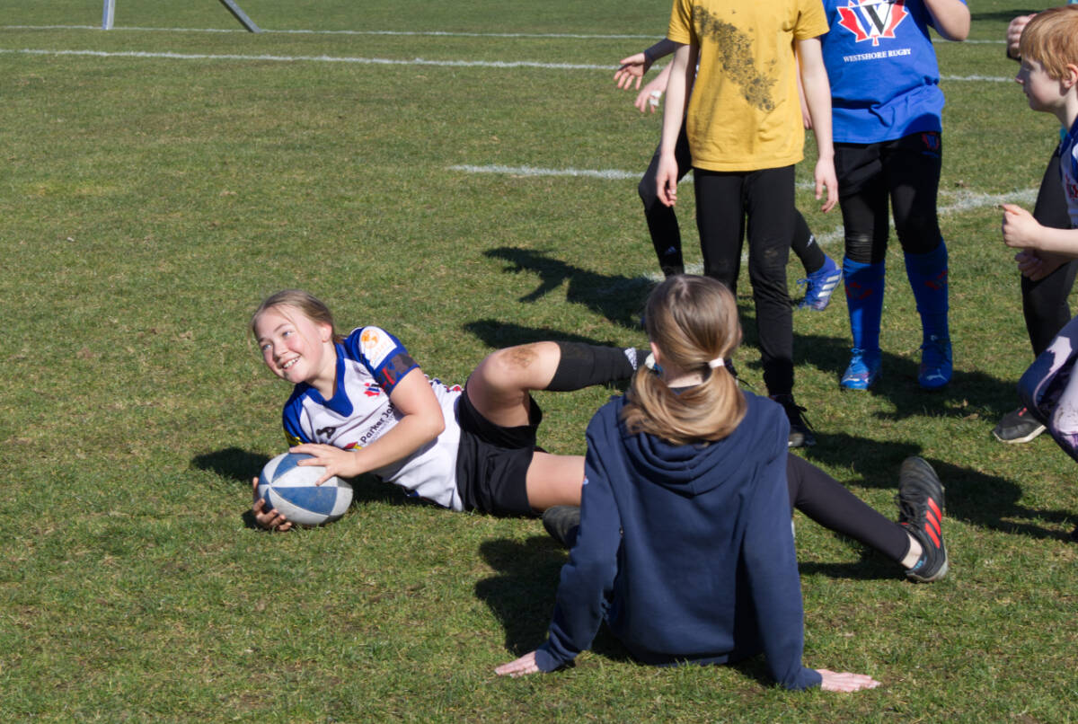 Kale’a Molia dives on the ball during training at the Westshore Rugby Club during the Girls Can Rugby event on March 6. (Bailey Moreton/News Staff)