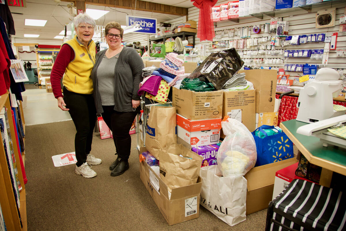 Cloth Castle owner Sylvia Ratcliffe and floor manager Natasha Cloutier show off the stack of donations bound for a children’s medical and trauma centre on the border between Poland and Ukraine. (Justin Samanski-Langille/News Staff)