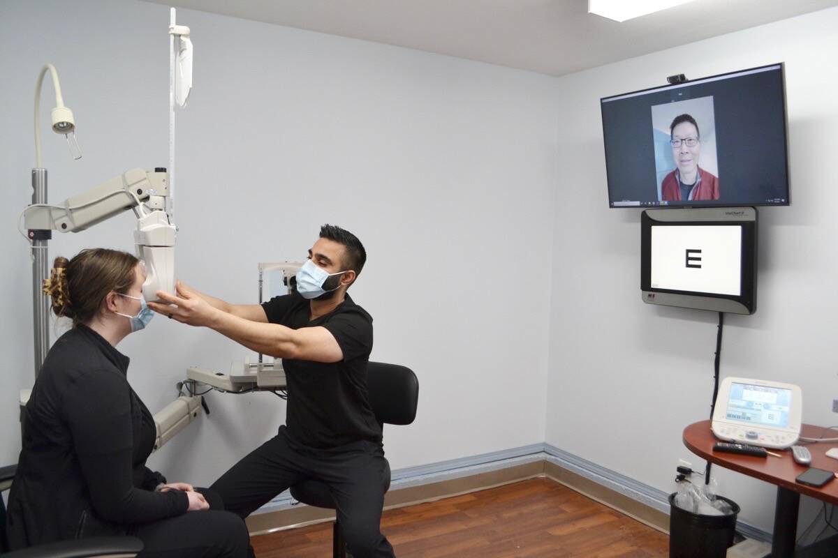 Dr. John Lam tunes in on the telehealth big screen as optometrist Dr. Gary Jassal tests the new equipment with eye care technician Eilidh Morrison during a Sunday training session in Hitacu. (Nora O’Malley photo)
