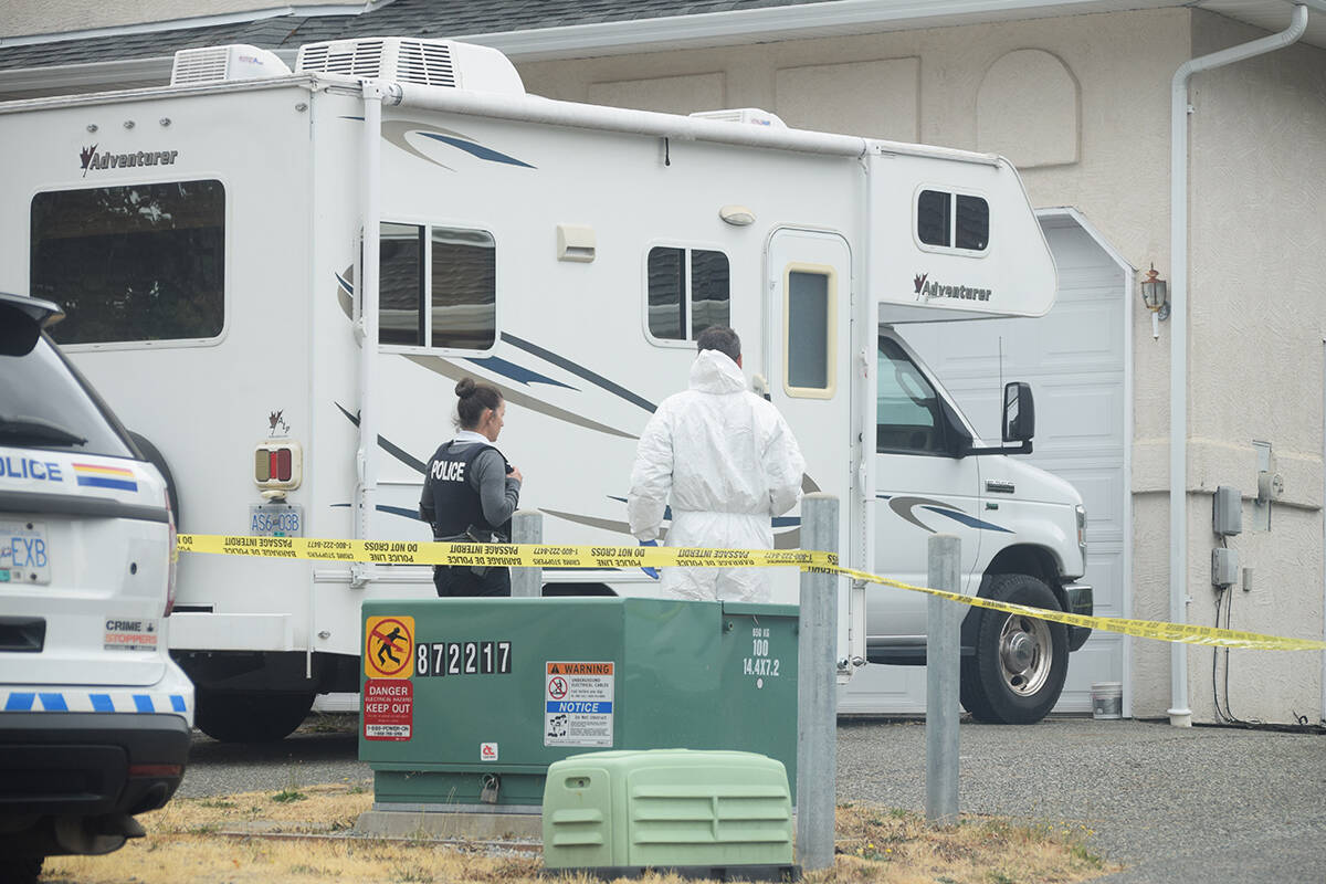 RCMP stand outside of a home on 18th Avenue near Argyle Street in Port Alberni where a man was shot to death Aug. 29, 2021. (ELENA RARDON / Alberni Valley News)