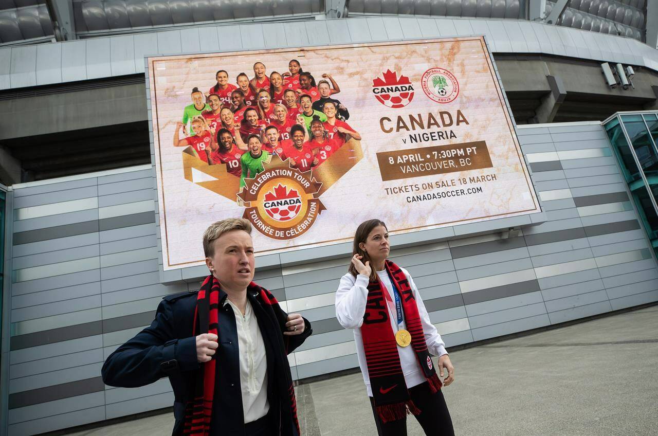 Canada women’s national soccer team head coach Bev Priestman, left, and goalkeeper Stephanie Labbe prepare to pose for a photograph outside B.C. Place stadium after an announcement, in Vancouver, on Wednesday, March 16, 2022. Soccer Canada announced that the women’s team will play Nigeria on April 8 in Vancouver and on April 11 in Langford, B.C. THE CANADIAN PRESS/Darryl Dyck