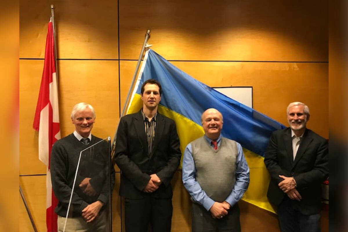 View Royal Couns. John Rogers and Damian Kowalewich stand with Mayor David Screech and Coun. Ron Mattson with a Ukrainian flag inside council chambers. Council approved a $10,000 donation to the Canadian Red Cross in support of aid efforts in Ukraine. (David Screech/Facebook)