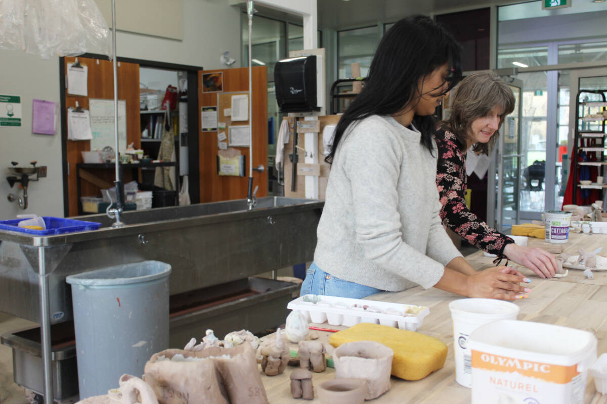 Artist and teacher Suvreet Juhal and District of Saanich community arts specialist Brenda Weatherston create ceramics together at the Cedar Hill Arts Centre. (Megan Atkins-Baker/News Staff)