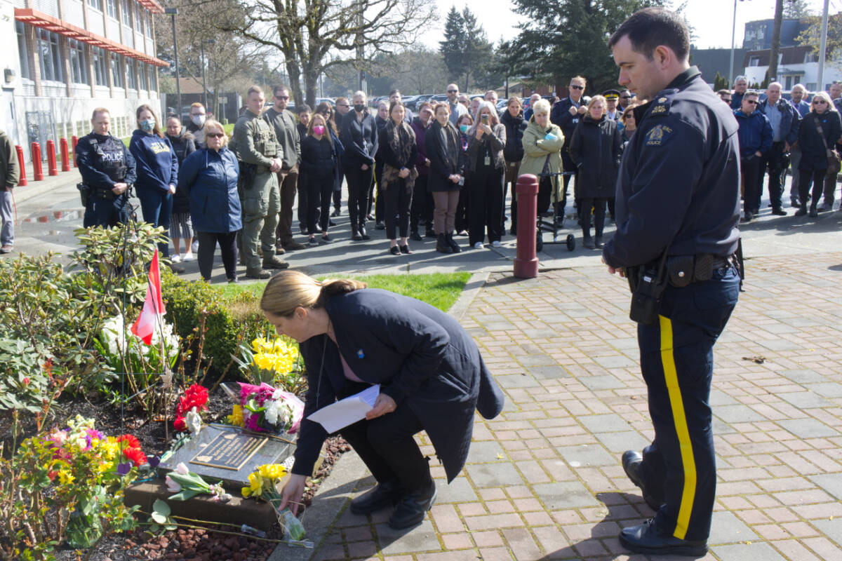Retired RCMP officer Kathy Rochlitz and Insp. Steve Rose lay flowers at the plaque commemorating Const. Sarah Beckett at a memorial outside West Shore RCMP on April 5, six years after she was killed in the line of duty. (Bailey Moreton/News Staff)