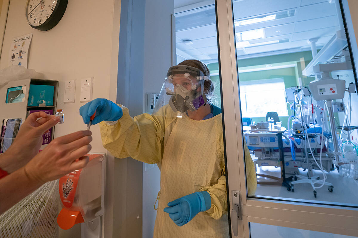 Registered nurse Dana Pagazzi receives supplies as she attends to a patient in the COVID-19 Intensive Care Unit at Surrey Memorial Hospital in Surrey, B.C., Friday, June 4, 2021. THE CANADIAN PRESS/Jonathan Hayward