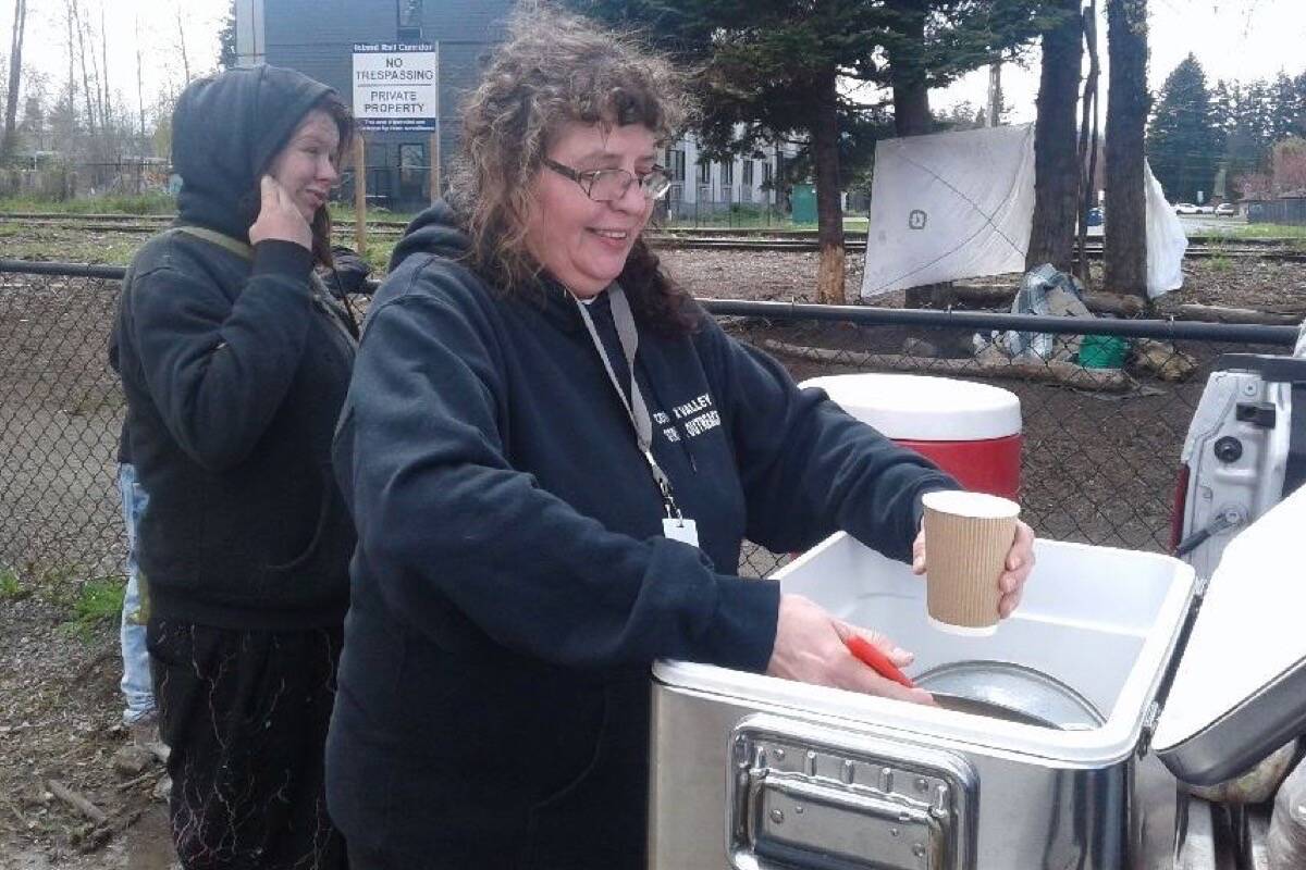 Sue Edwards dishes out soup to a woman in Courtenay. Scott Stanfield photo