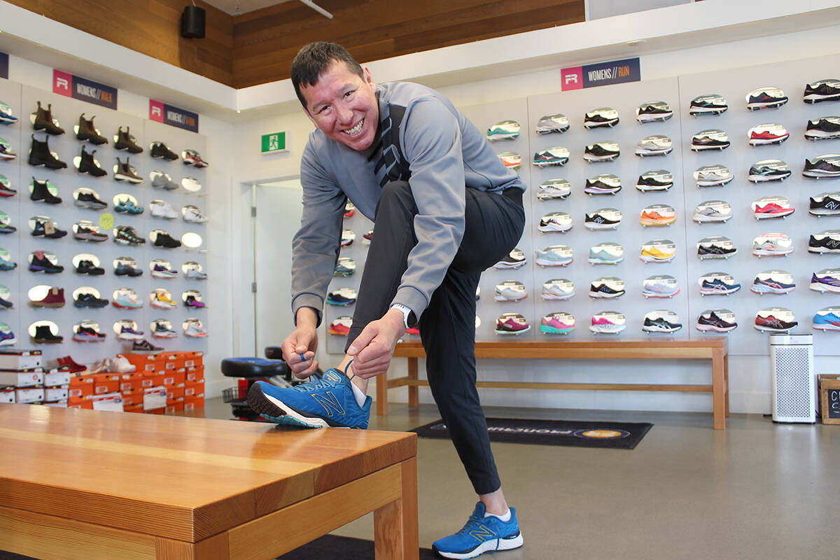 Tarrant Cross Child laces up a pair of running shoes at Frontrunners Nanaimo on Friday, April 29, before heading to speak to elementary school students. (Greg Sakaki/News Bulletin)