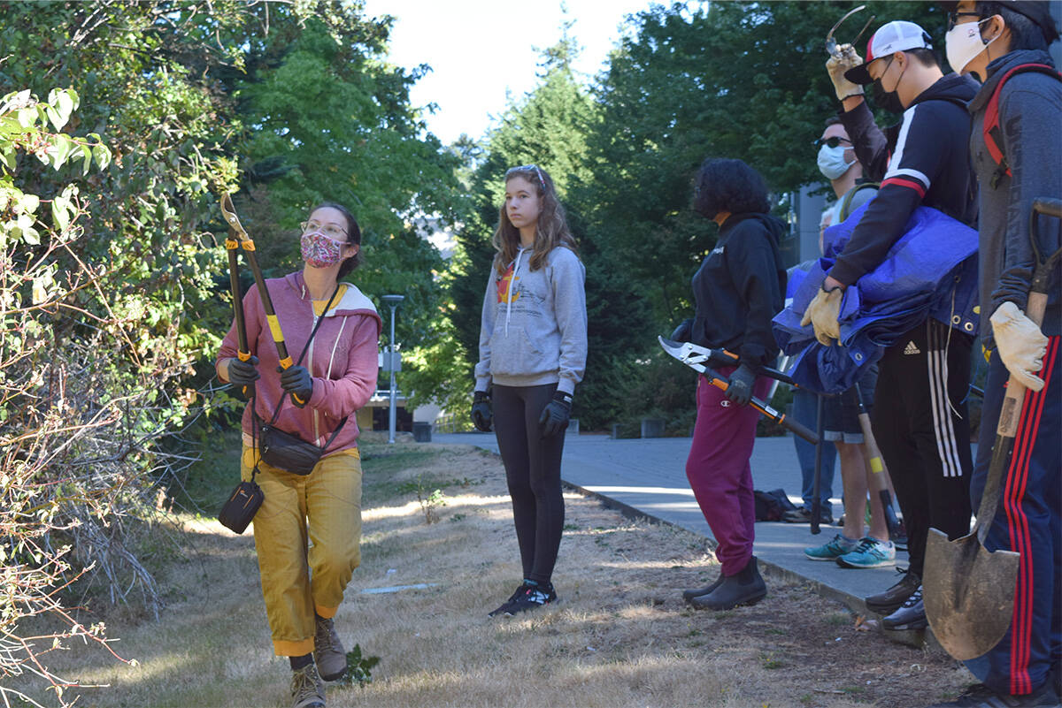 Amanda Evans, left, instructs Green Team Greater Victoria volunteers on where to cut invasive species at a previous event. The group is seeking volunteers for a busy slate of events this month. (Black Press Media file photo)