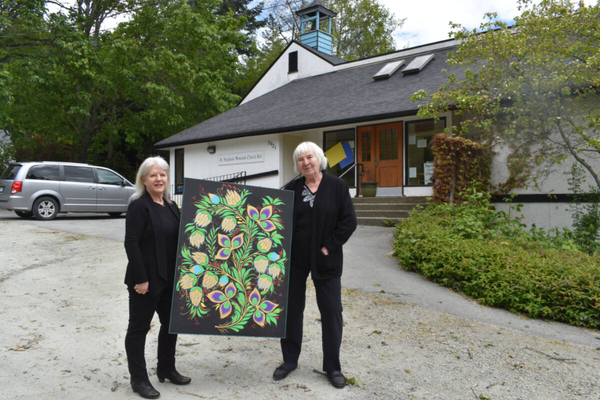Pam Rowden and Lois Shannon hold up ‘Slavic Artichoke’ by local artist L. Thiessen, one of his 25 original pieces that are part of a silent auction running Saturday, May 28 from 10 a.m. until 4 p.m. at St. Stephens Church in Central Saanich. (Wolf Depner/News Staff)