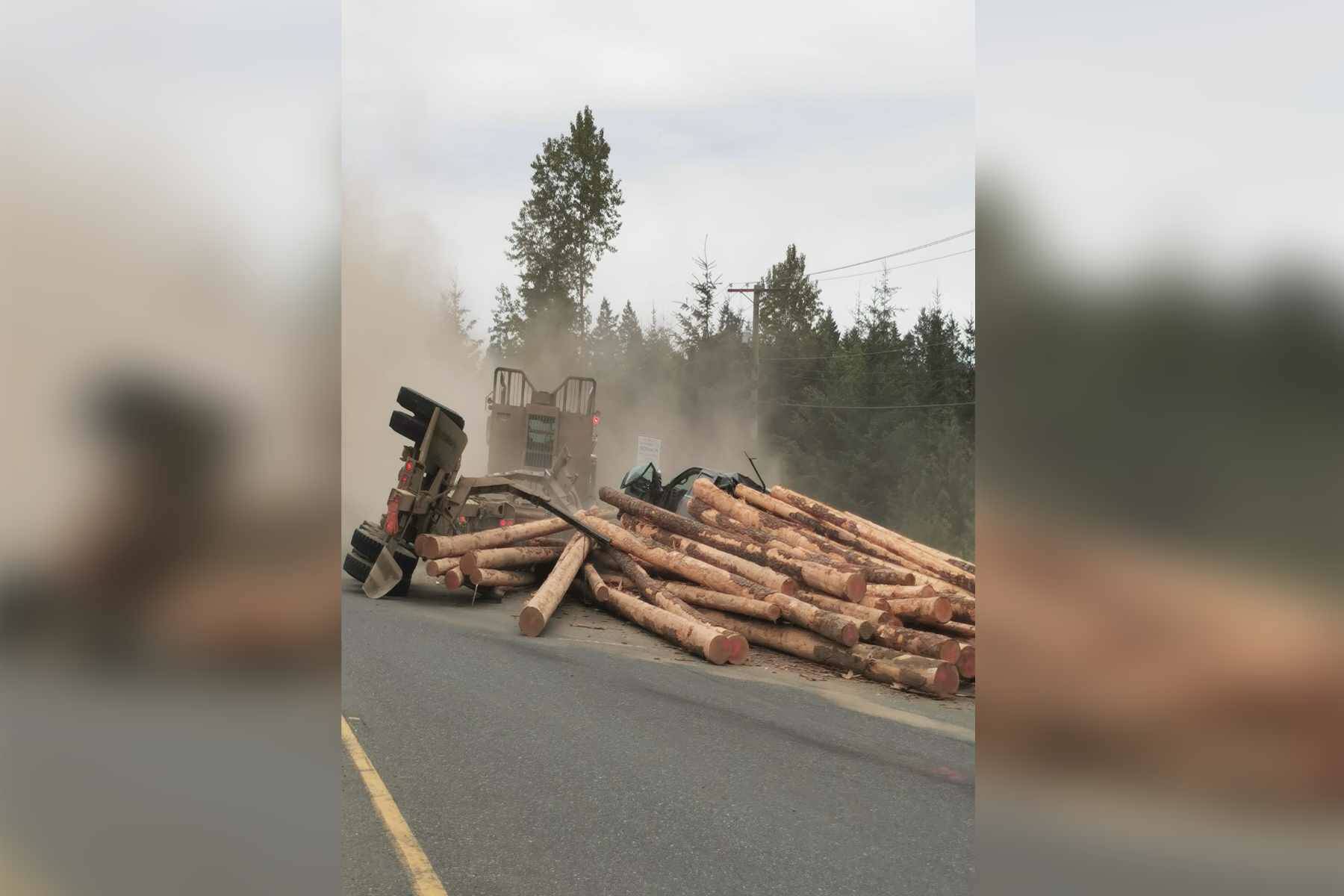 A logging truck lost its load on top of a pickup truck Tuesday (May 24) afternoon in the Comox Valley on the on-ramp to Highway 19. Photo by Pamela Tessmann