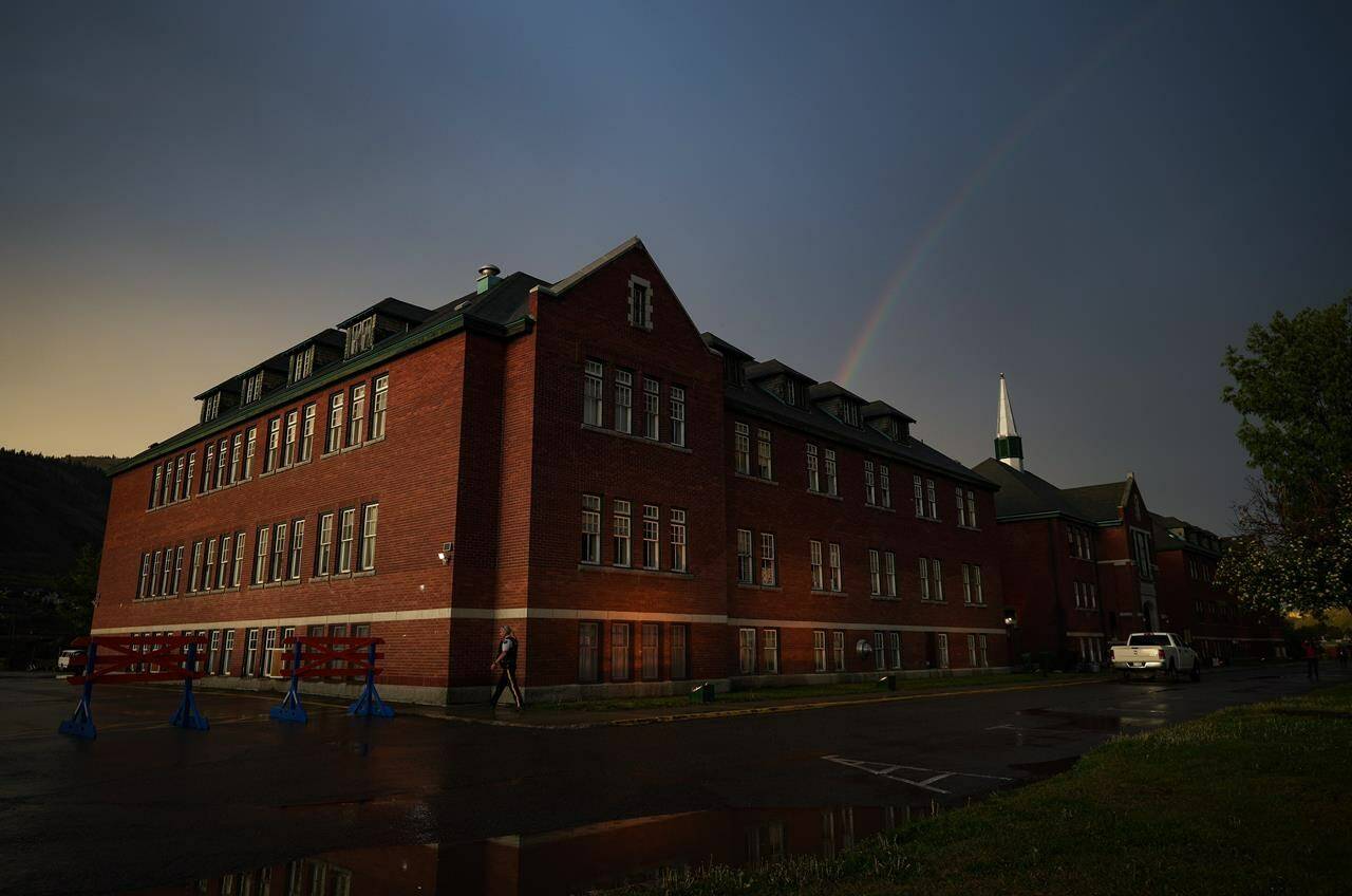 A rainbow is seen above the former Kamloops Indian Residential School after a day-long ceremony to mark the one-year anniversary of the Tk’emlups te Secwepemc announcement that 215 suspected unmarked graves had been detected at the former residential school, in Kamloops, B.C., on Monday, May 23, 2022. THE CANADIAN PRESS/Darryl Dyck