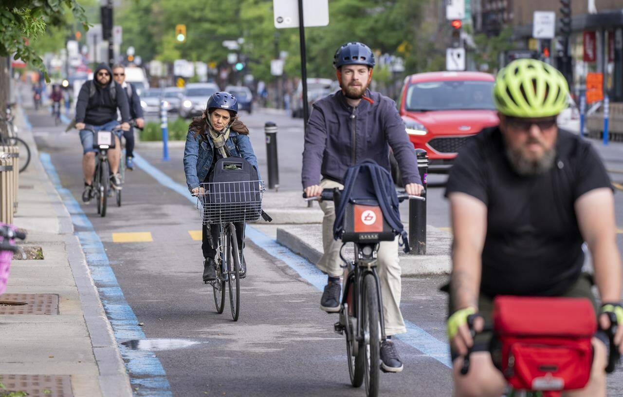 Cyclists make their way down the REV — Reseau Express Velo — on St-Denis Street during the morning commute in Montreal on Thursday, June 2, 2022. THE CANADIAN PRESS/Paul Chiasson