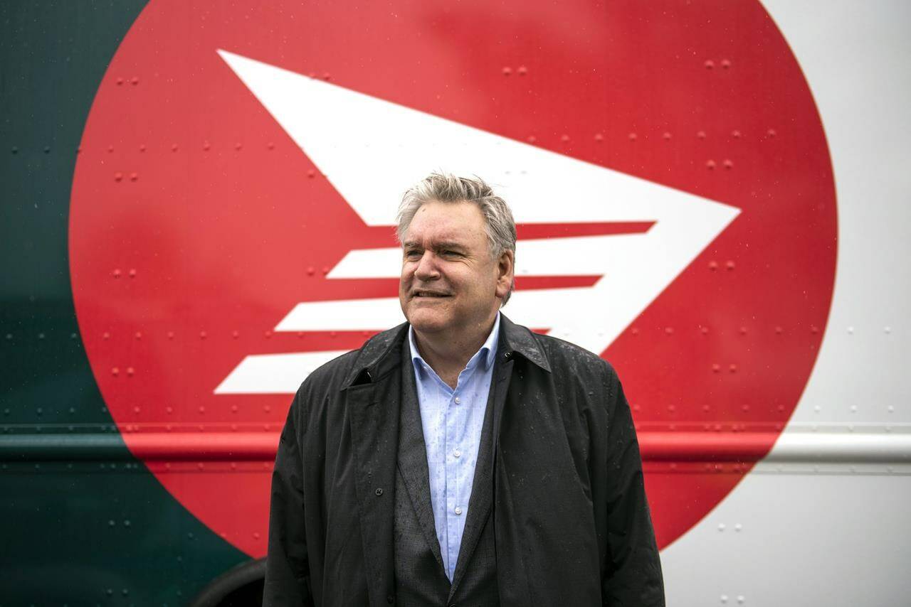 Canada Post CEO Doug Ettinger poses in front of an electric delivery vehicle after a news conference on the postal service’s plans to transform their fleet of 14,000 vehicles, in Ottawa, on Thursday, June 9, 2022. THE CANADIAN PRESS/Justin Tang