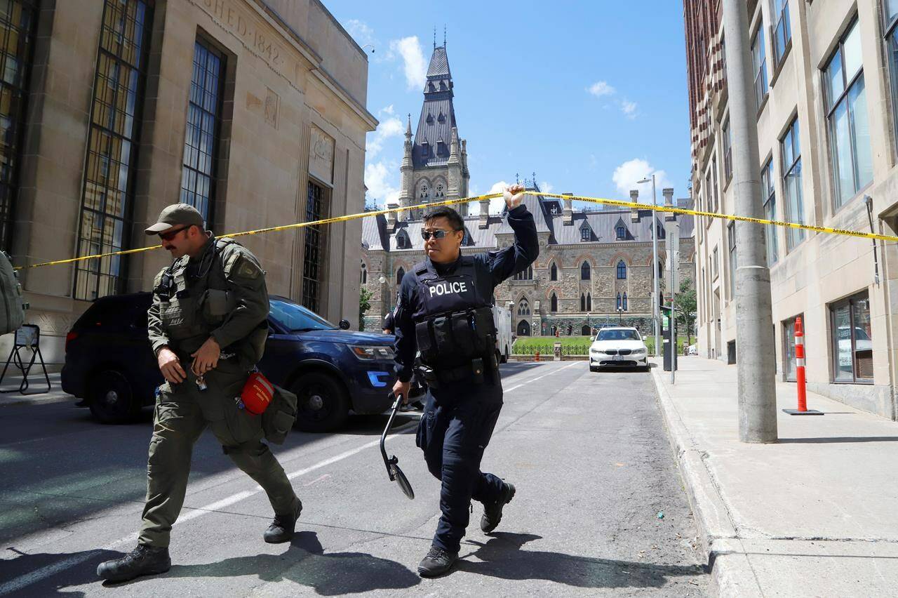 Police respond to an incident on Parliament Hill in Ottawa on Saturday, June 11, 2022. Two organizers of a rally set to take place on Parliament Hill Saturday say they were arrested and released soon after by police for being wrongfully identified in connection to a bomb threat in the area.THE CANADIAN PRESS/ Patrick Doyle