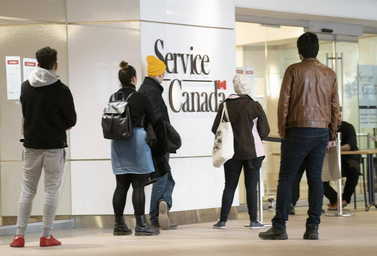 People line up at a Service Canada office in Montreal on Thursday, March 19, 2020. THE CANADIAN PRESS/Paul Chiasson