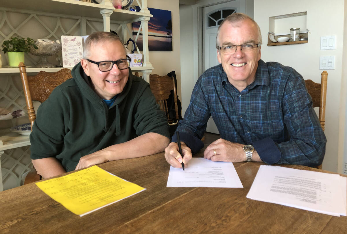 Orlando Sumner, left, and Bernie Willock signing the original agreement for the purchase of the former St. Joseph’s School. (File photo)