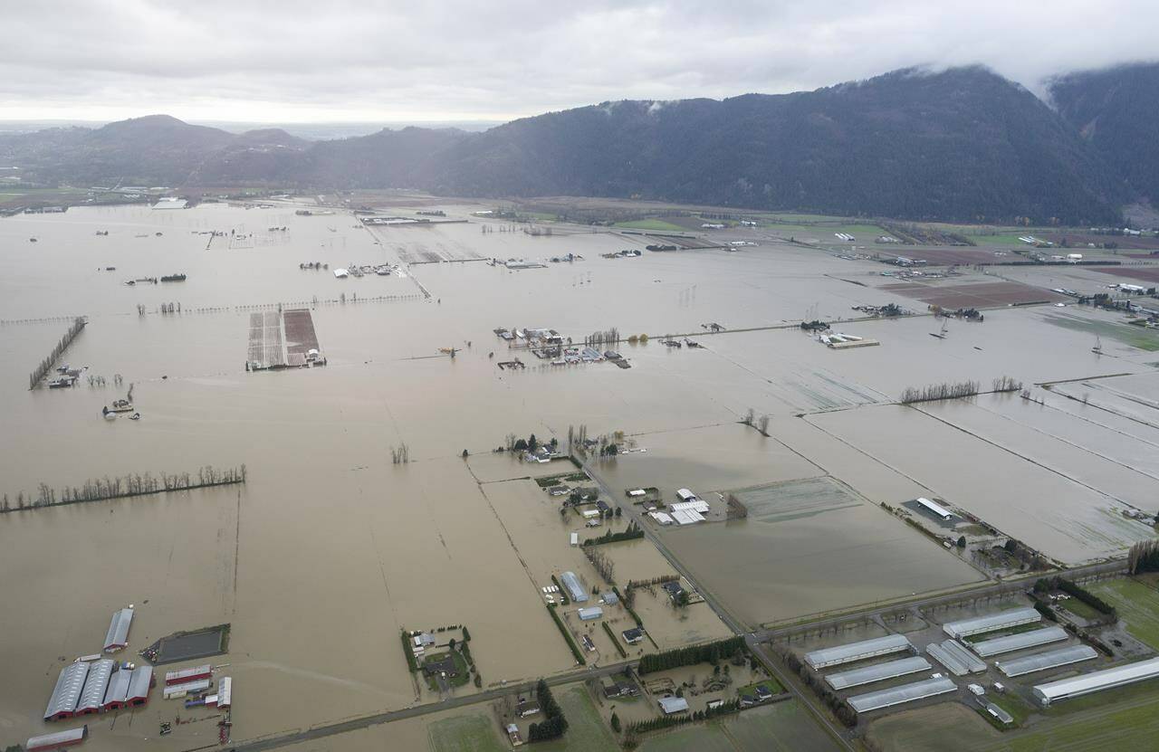 Floodwaters are seen from the air in Abbotsford, B.C., on Nov. 23, 2021. November’s floods in British Columbia that swamped homes and farms, swept away roads and bridges and killed five people are now the mostly costly weather event in provincial history. THE CANADIAN PRESS/Jonathan Hayward