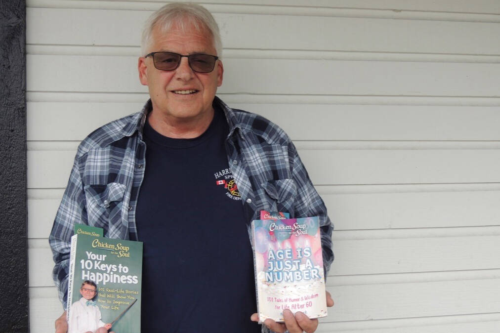 Harrison Firefighter Fred Webber smiles as he holds copies of the two Chicken Soup for the Soul books that contain his story. (Adam Louis/Observer)