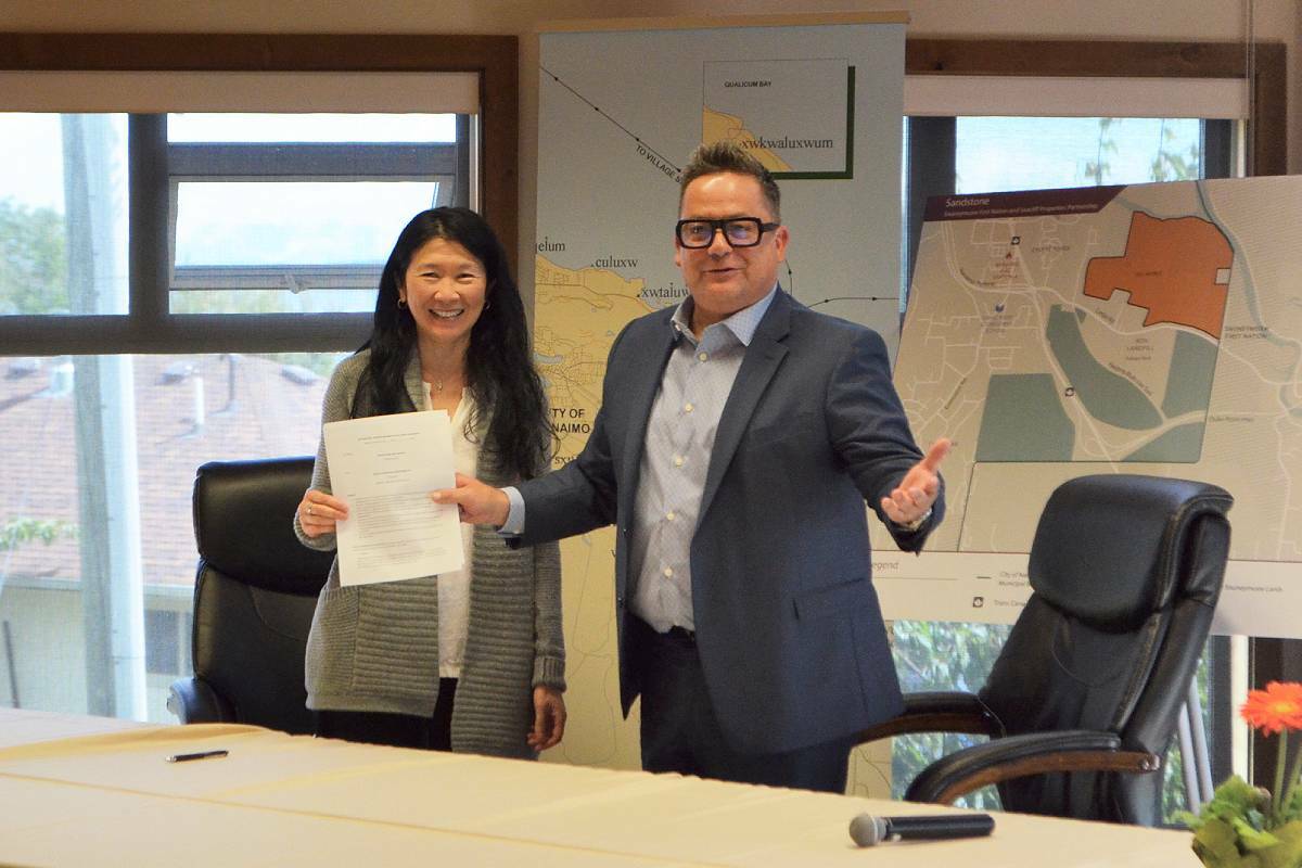 Jeany Lee, director of acquisitions and asset management with Seacliff Properties, and Snuneymuxw First Nation acting chief William Yoachim sign an agreement June 22 to potentially transfer 106 hectares of traditional Snuneymuxw land back in their Sandstone project planned for south Nanaimo. (Mandy Moraes/News Bulletin)