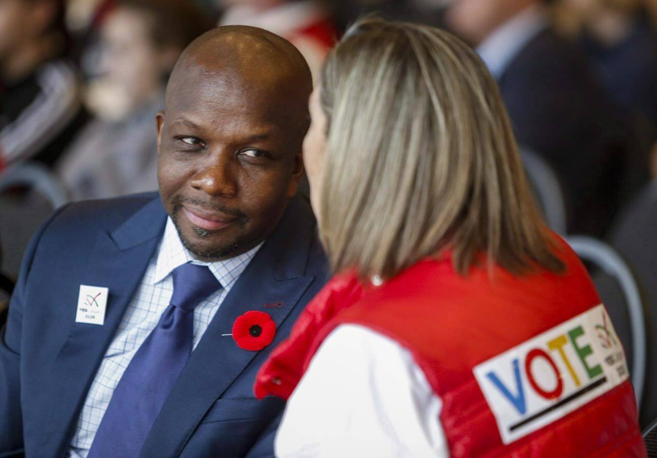 Former Olympian Donovan Bailey, left, speaks to a fan during a rally in support of the 2026 Winter Olympic bid in Calgary, Alta., Monday, Nov. 5, 2018. Bailey is among the dozens of performers, athletes, advocates and experts newly named to the Order of Canada on Wednesday. THE CANADIAN PRESS/Jeff McIntosh