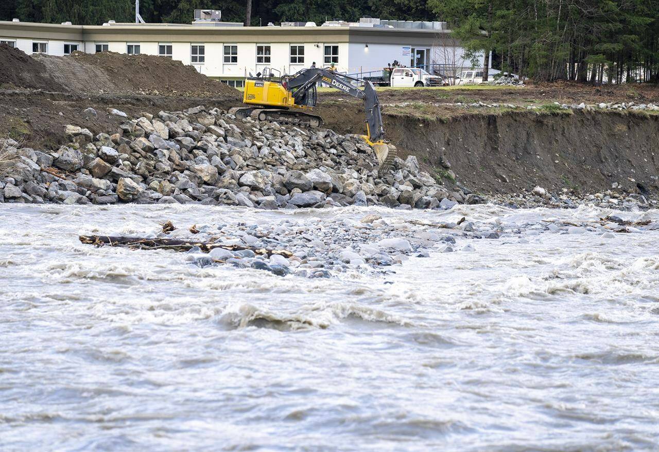 An excavator places rock along a bend in the Coquihalla River in Hope, B.C., Thursday, Dec. 2, 2021. The River Forecast Centre has issued another flood watch as heavy rains swell a waterway that winds through parts of Kelowna, B.C. The centre says flows on Mission Creek increased rapidly overnight and will continue to rise through Tuesday with additional rainfall. THE CANADIAN PRESS/Jonathan Hayward