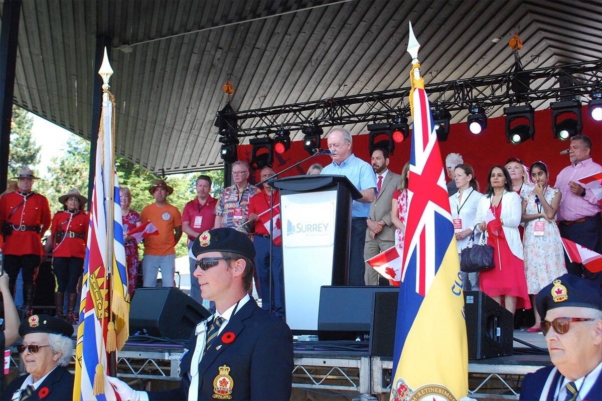 Surrey Mayor Doug McCallum takes to the stage in Cloverdale during Canada Day, with other dignitaries including MP Sukh Dhaliwal (stage left) and Mounties in red serge (stage right). (Photo: City of Surrey)
