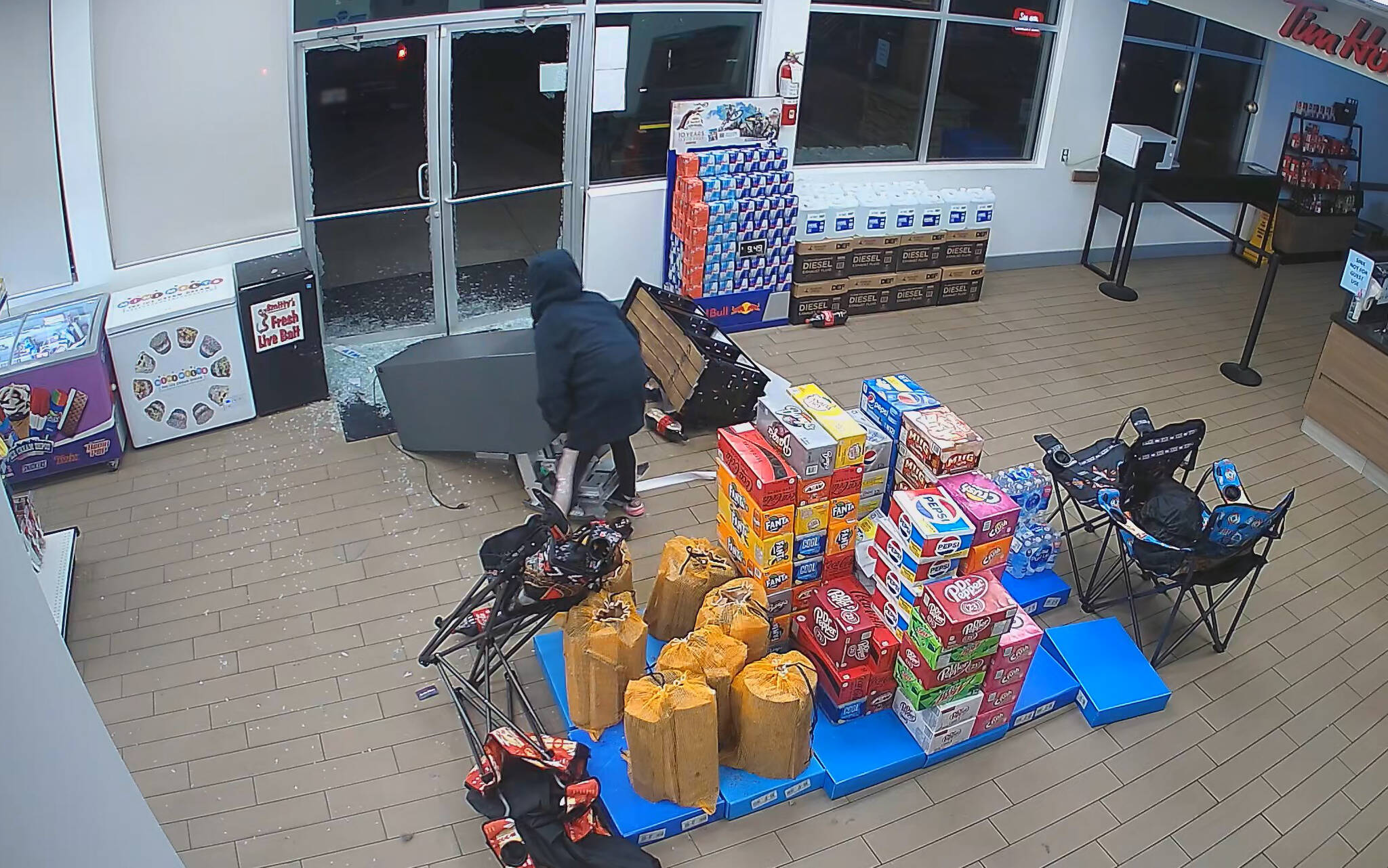 A suspect (caught by video camera) attempts to wheel out an ATM from a local convenience store. / Submitted Photo