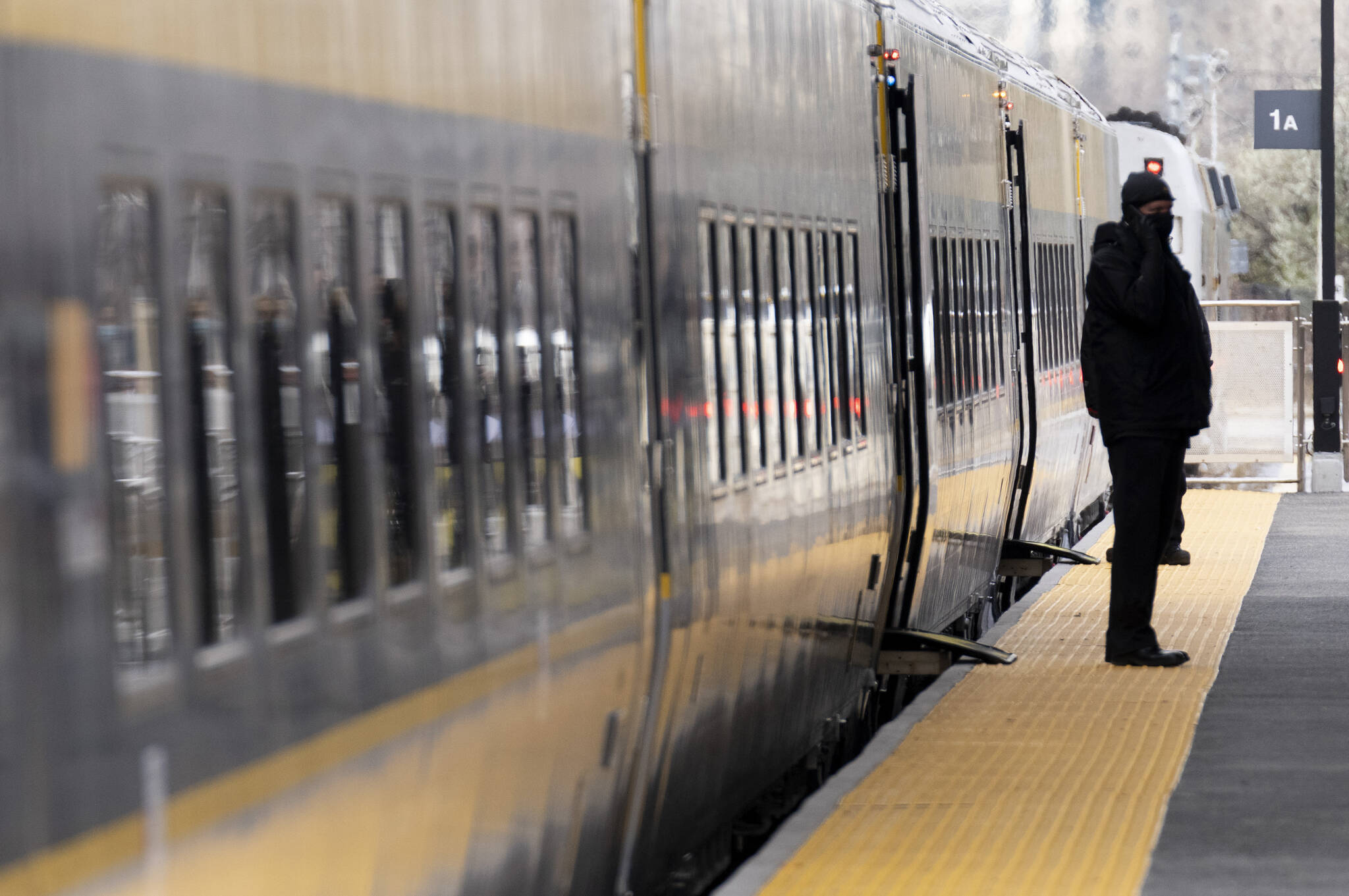 A Via Rail employee stands beside the entrance to a new train on display at the train station in Ottawa, Tuesday, November 30, 2021 in Ottawa. THE CANADIAN PRESS/Adrian Wyld